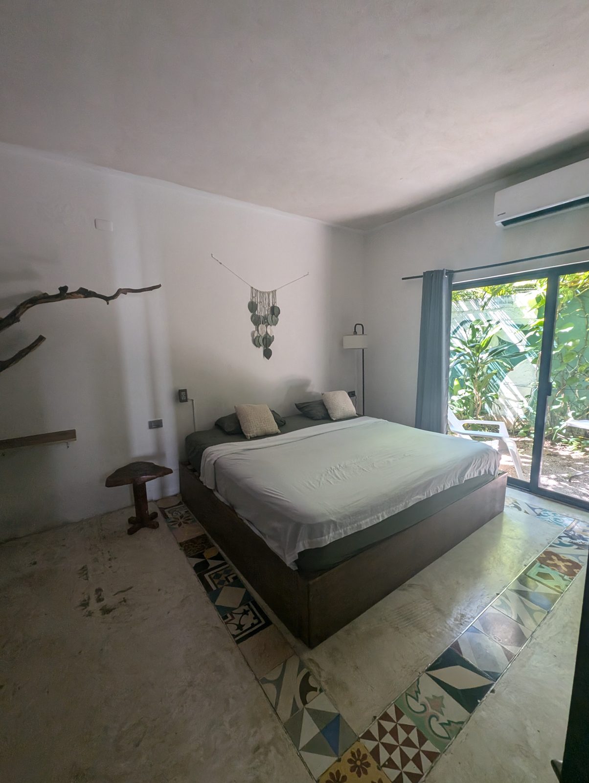 Private suite with king bed and patterned tile floor at Maui Hostels Tulum